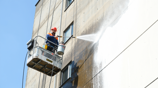 高端住宅小区外墙清洁项目，工人正在清洁大面积玻璃窗和装饰面板，现代住宅建筑群